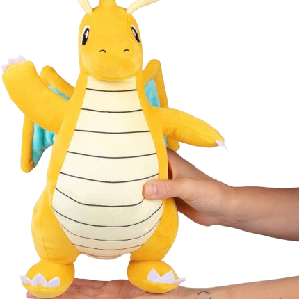 Plush toy resembling a dragon character held by a person on a white background
