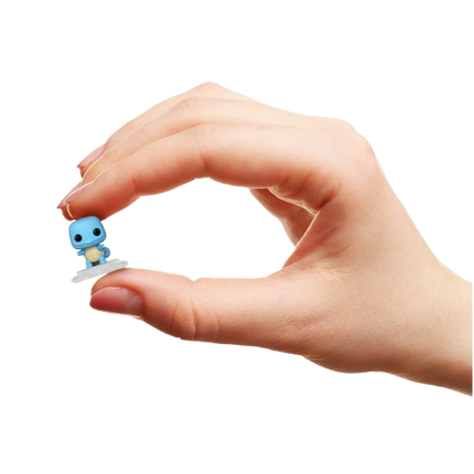 Small blue figurine held in a hand against a white background